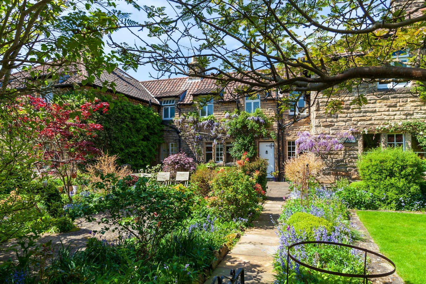 A stone country house with a flowering garden